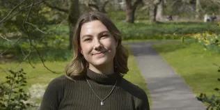Photo of Cristi on a sunny day in George Square gardens at the University of Edinburgh