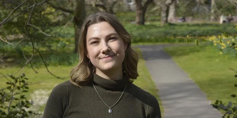 Photo of Cristi on a sunny day in George Square gardens at the University of Edinburgh