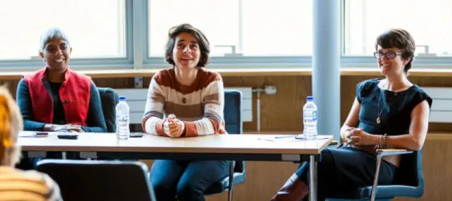 Three students sit at a table