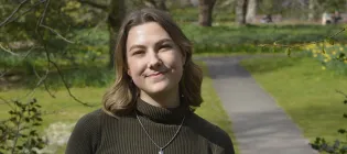 Photo of Cristi on a sunny day in George Square gardens at the University of Edinburgh