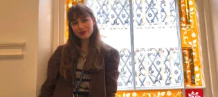 Susanna Demelas in front of a mosaic window