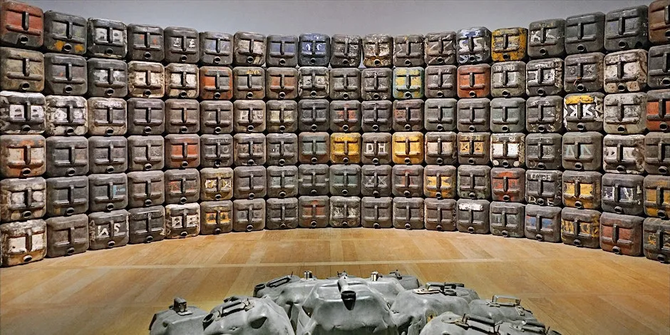 A pile of water canisters arranged in a semi-circle on top of each other, they are reminiscent of faces