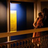 Photo of a group of visitors to Talbot Rice Gallery looking at one of the panels from the exhibition the nature of difference