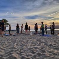 People on a beach doing yoga