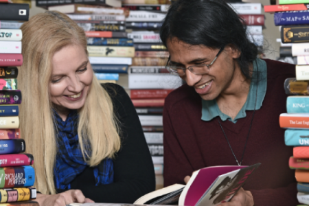 Two women reading amongst a pile of books