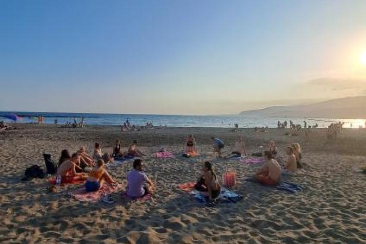 People on a beach doing yoga