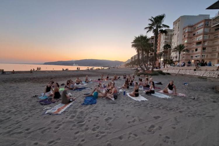 People on a beach doing yoga