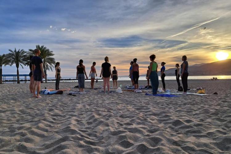 People on a beach doing yoga