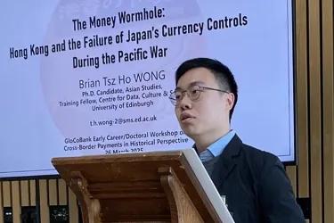 Photo of Tsz Ho at a lectern giving a presentation