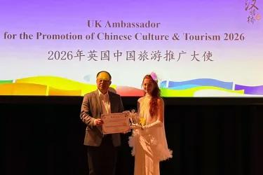 Photo of a student on the right being awarded a prize at a contest.