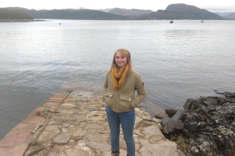 Isla Parker by a lake in the Scottish highlands