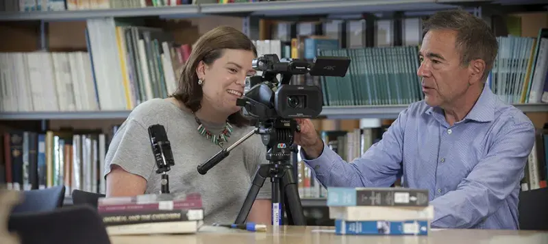 Photo of two people using recording equipment