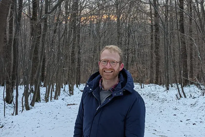 Photo of Mark Bradshaw standing in a forest looking at the camera