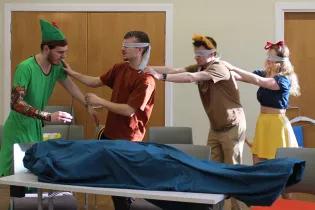A photo of three people wearing blindfolds in a rehearsal for a play