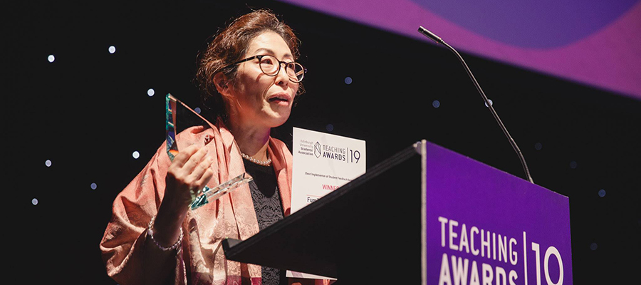 Photo of teacher Fumiko accepting an award