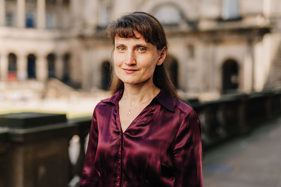 Photo of Katia Popova at Old College, University of Edinburgh. It is a head and shoulders shot; she is looking at the camera.