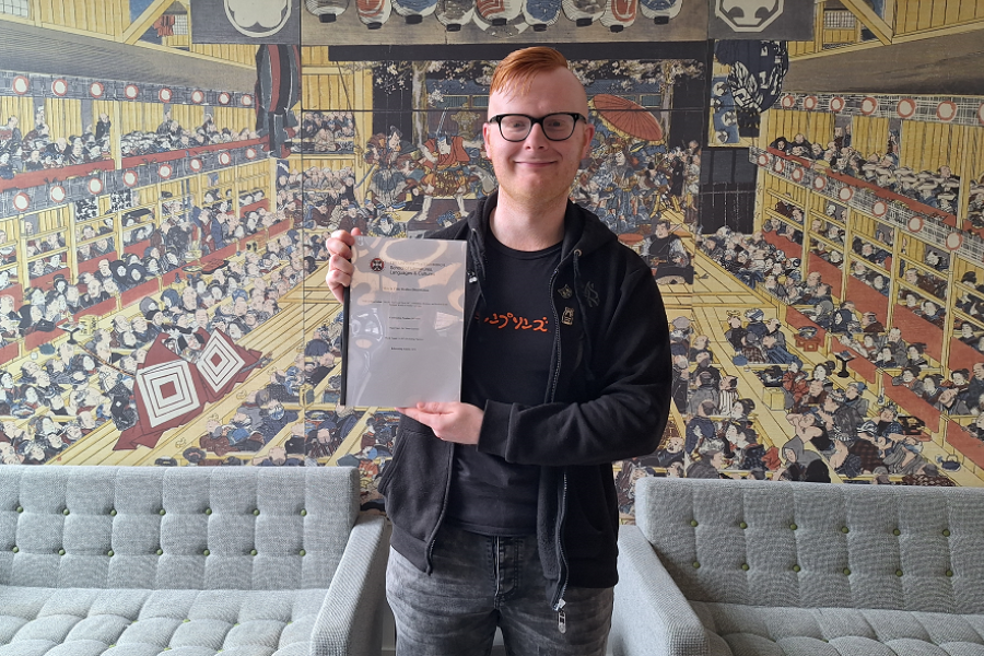 James with his dissertation, in front of a piece of art on the 4th floor of 50 George Square