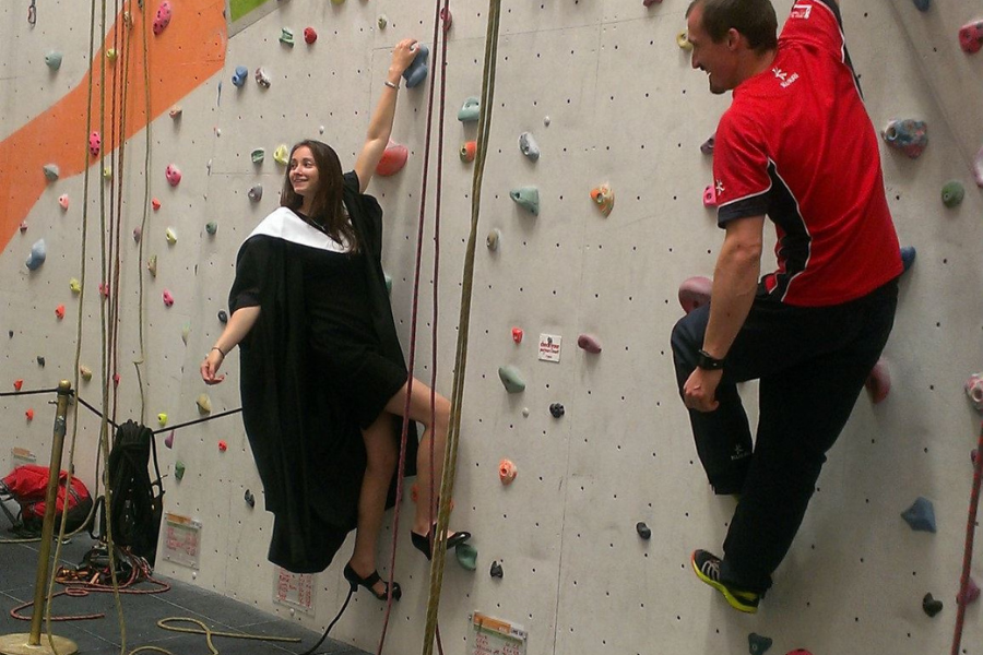Natalie on a climbing wall on graduation day